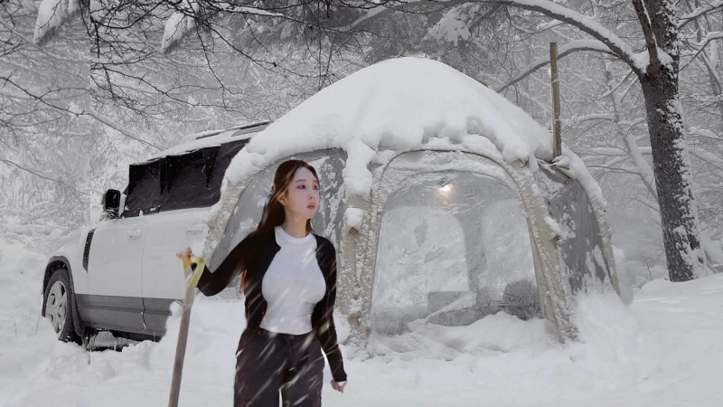 令人惊叹的玻璃圆顶充气帐篷单人车露营在雪林